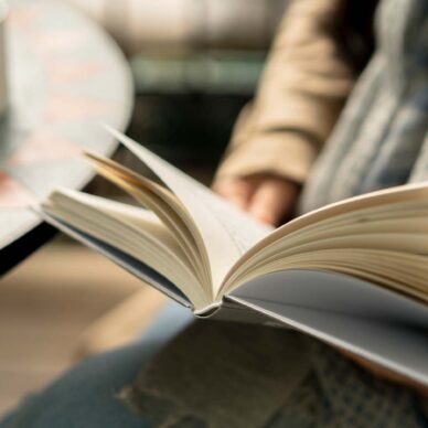 Reading book while drinking coffee on balcony